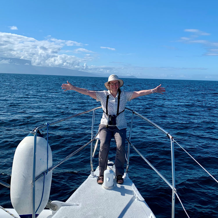 Kathryn Frieden with her arms outstretched on a boat in the ocean. Photo by her husband, Roger.